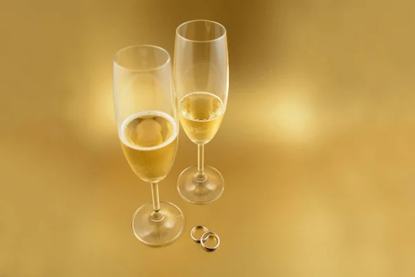 シャンパンのストック イメージの結婚指輪 金婚式の背景 バレンタインの日の概念 金色の背景にコピーのテキストのための領域のシャンパン お祝い金背景 — ストック写真