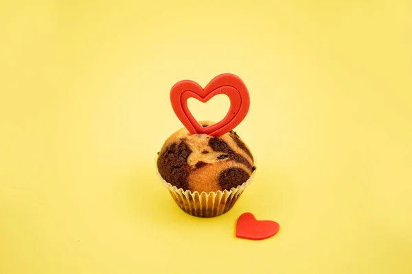 心のストック イメージのマフィン 黄色の背景に心とチョコレートのマフィン 甘い誕生日のペストリー バレンタインの日の概念 — ストック写真
