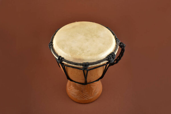 Изображения африканского барабана. Деревянный барабан с козьей кожей, этнический музыкальный инструмент. Джембе Барабан на коричневом фоне
