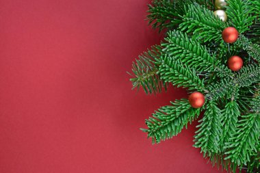 Ağaç dalları üzerindeki Noel süslemeleri topları. Kırmızı arka planda Noel ağacı dalları. Güzel, doğal bir Noel geçmişi. Kırmızı arka planda Xmas dekorasyonu. Noel kırmızı çerçeve stok resimleri