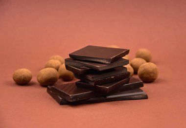 Chocolate sweets stock images. Pile of Chocolate stock images. Dark chocolate on a brown background. Assorted chocolate candies isolated on a brown background