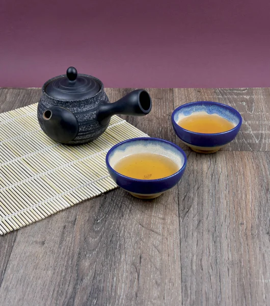 Traditional Chinese tea on the table stock images. Ceramic brown tea set stock images. Traditional chinese tea set frame arrangement. Ceramic teapot with cup stock images. Green tea  on a wooden background with copy space for text