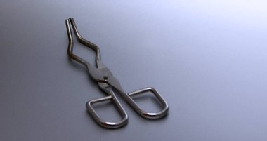 Crucible Tongs stock images. Laboratory tweezers images. Laboratory accessories images. Laboratory equipment on a silver background with copy space for text