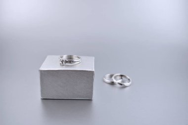 Nişan yüzüğü ya da alyans resmi. Hediye kutusunda yüzük. Teklif günü konsepti. Elmas alyans hediye çeki. Metin için kopyalama alanı olan gümüş düğün arkaplanı
