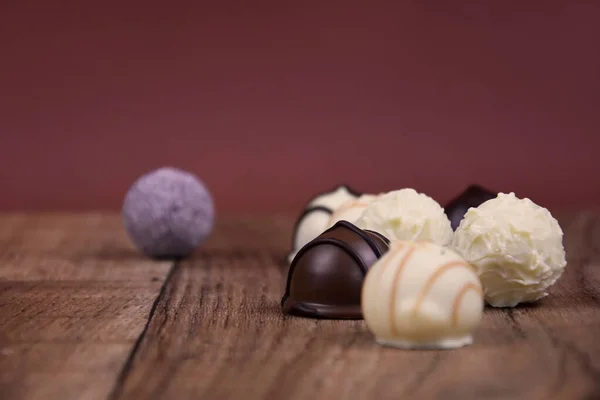 木製の背景ストック画像上のチョコレートのプラリネ チョコレートキャンディーの画像の異なる種類 テーブルの上のチョコレートキャンディー チョコレートプラリネフレーム付きコピースペース — ストック写真