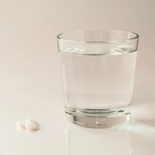 Pills and glass Royalty Free Stock Images