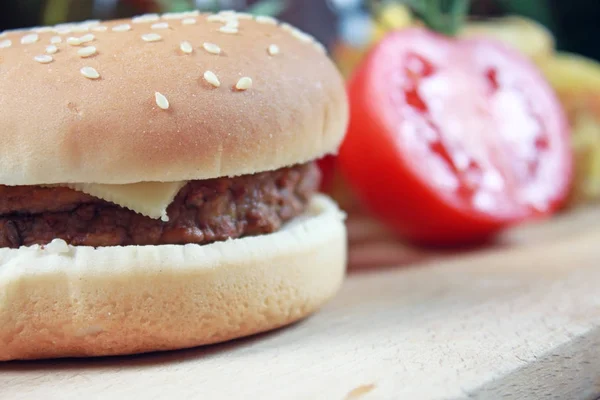 Zbliżenie Cheeseburger Świeżych Pomidorów Drewnianym Stole — Zdjęcie stockowe