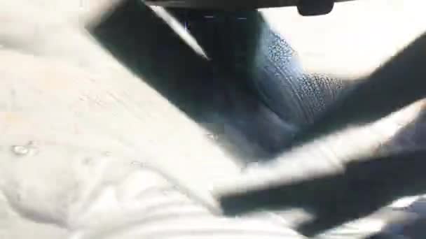 mousse coule sur la vitre avant d'une voiture dans le lavage de voiture 