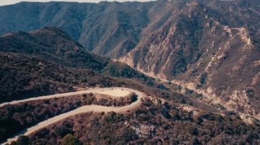 Sinema dağ oluşumları Malibu'da bir helikopterden görünümünü hava panoramik video. Dağ yolundan tepelerin üst boyunca çalışır. Los Angeles, Kaliforniya, ABD