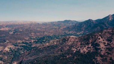Sinema dağ oluşumları Malibu'da bir helikopterden görünümünü hava panoramik video. Dağ yolundan tepelerin üst boyunca çalışır. Los Angeles, Kaliforniya, ABD