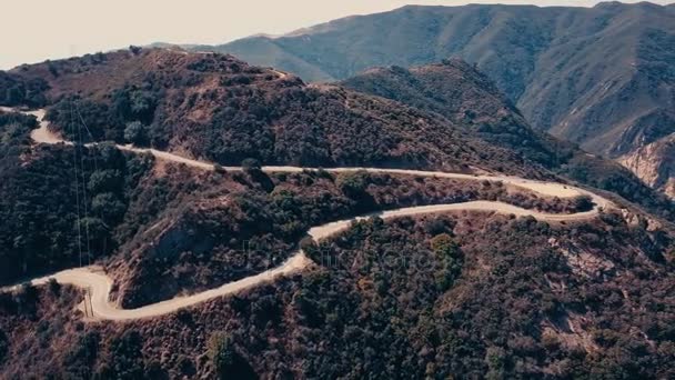 Kino lotnicze panoramiczne wideo widok na górskie formacje w Malibu z helikoptera. Górska droga biegnie wzdłuż górnej części wzgórza. Los Angeles, California, Stany Zjednoczone Ameryki — Wideo stockowe