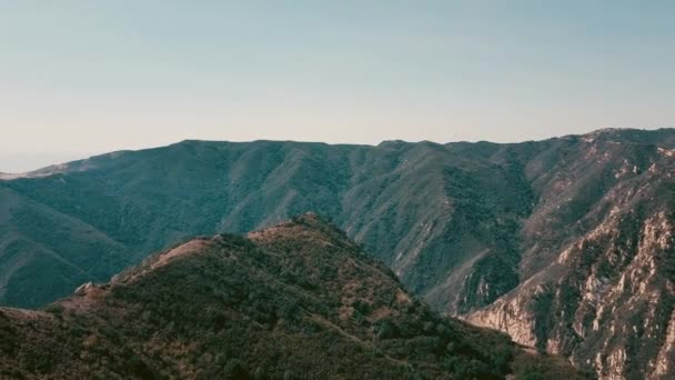 Sinema dağ oluşumları Malibu'da bir helikopterden görünümünü hava panoramik video. Uçan bir dağ sırtı tepesinden. Los Angeles, Kaliforniya, ABD — Stok video