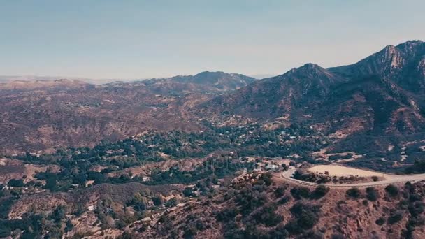 Sinema dağ oluşumları Malibu'da bir helikopterden görünümünü hava panoramik video. Dağ yolundan tepelerin üst boyunca çalışır. Los Angeles, Kaliforniya, ABD — Stok video