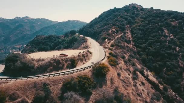Kino letecké panoramatické video z pohledu horské formace v Malibu z vrtulníku. Horská silnice vede podél horní části kopce. Los Angeles, Kalifornie, Usa — Stock video