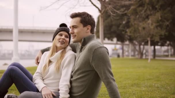 Pareja enamorada abrazándose en un parque una agradable noche cerca del océano . — Vídeo de stock