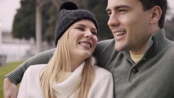 Couple in love cuddling in a park a pleasant evening near the ocean. — Stock Video