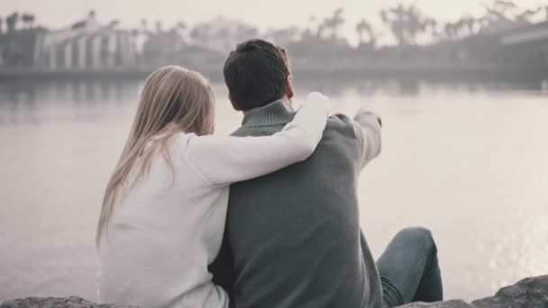 Verliebtes Paar sitzt im Gras und umarmt sich in einem Park — Stockvideo