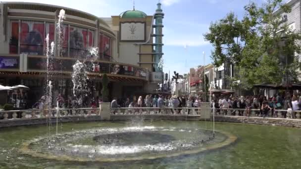 The Grove, Los Ángeles, California, EE.UU. - 6 de abril de 2018. La gente camina cerca de la fuente. Centro comercial de gama alta cuenta con minoristas de moda, restaurantes un teatro en medio de un bullicioso paseo marítimo — Vídeos de Stock