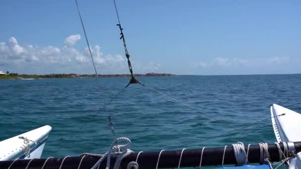 Катамаран парусной яхты плавает по волнам в теплом Карибском море. Парусник. Парусник. Канкун Мексика. Летний солнечный день, голубое небо с облаками — стоковое видео