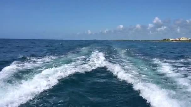 Trilha na superfície da água atrás de catamarã de motor em movimento rápido no Mar do Caribe Cancún México. Verão dia ensolarado, céu azul com nuvens — Vídeo de Stock