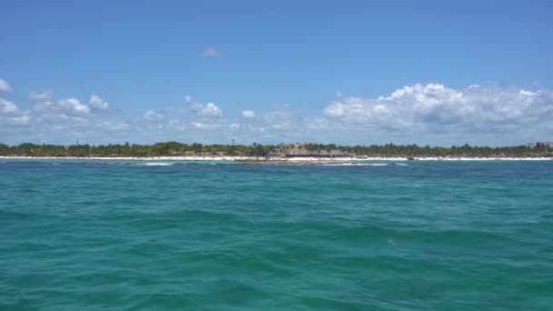 Vista da costa a partir do barco nas ondas no Mar do Caribe quente. Riviera Maya México. Verão dia ensolarado, céu azul com nuvens — Vídeo de Stock