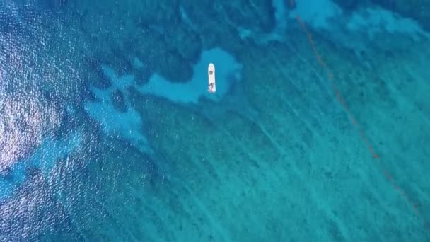 Drohnenschuss aus der Luft. Blick von oben auf das Boot mit Tauchern in der Ferne aus der Vogelperspektive. türkisfarbenes Wasser mit Blick auf die Korallenküste der Karibik. Riviera Maya Mexiko — Stockvideo