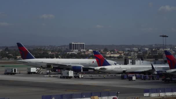 Los Angeles, Ca Spojené státy americké - 10 02 2019: Letadla Delta vykládají a nakládají v blízkosti terminálu v Lax, mezinárodní letiště Los Angeles. — Stock video