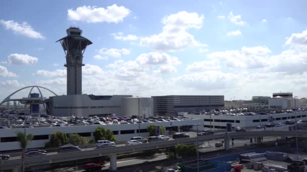 Los Angeles, CA United States - 10 02 2019: Cars traffic at LAX. A lot of cars in the parking lot against the background of the control tower. Los Angeles International Airport. — Stock Video