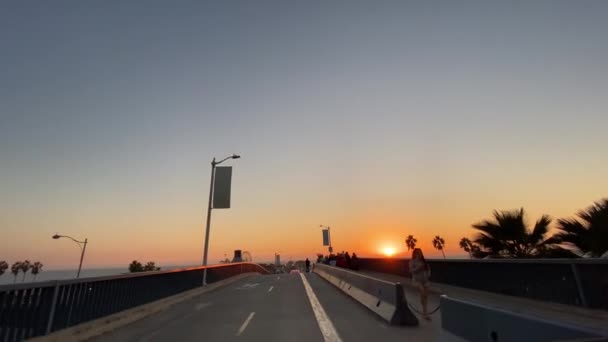 LOS ANGELES, EUA - 18 de dezembro de 2019: O carro desce a estrada para o cais de Santa Mônica ao pôr-do-sol em Los Angeles, Califórnia, EUA . — Vídeo de Stock