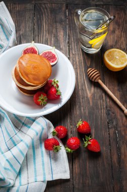 fincan çay ve krep ile incir, çilek beyaz tabak portre üzerinde