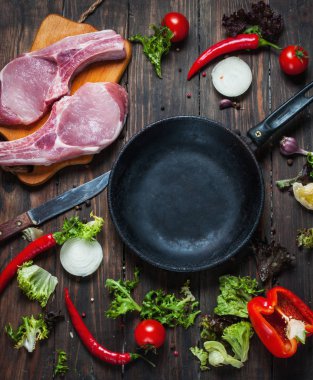 Çiğ domuz biftek otlar, biber ve sarımsak metin, çerçeve ahşap rustik arka plan en iyi görünüm için pan yer çevresinde