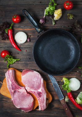 Çiğ domuz biftek otlar, biber ve sarımsak metin, çerçeve ahşap rustik arka plan en iyi görünüm için pan yer çevresinde