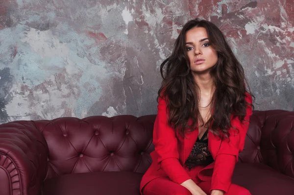 Portrait of a sexy young business lady in a red suit on a dark s — Stock Photo, Image