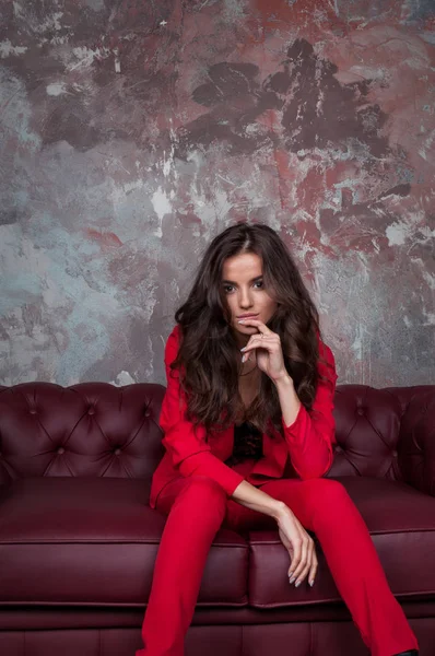 Retrato de una joven mujer de negocios sexy en un traje rojo en una s oscura —  Fotos de Stock