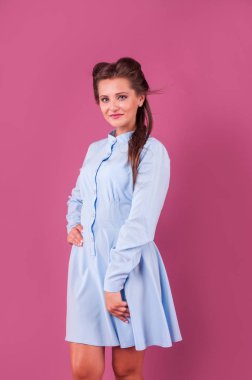 Studio pembe arka plan üzerinde mavi bir elbise güzel kadın