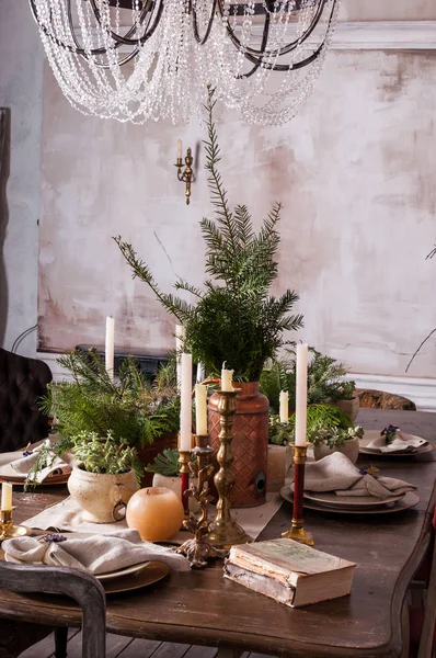 Dining table decorated for Christmas and evergreen centerpiece