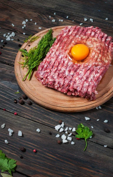 Carne picada cruda casera con huevo y hierbas de primer plano —  Fotos de Stock