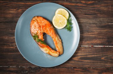 Ahşap arka plan üzerinde limonlu ızgara somon