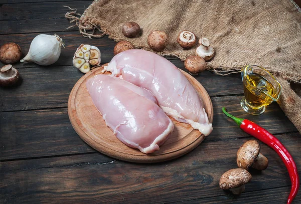 Chicken fillet and mushrooms on a wooden table — Stock Photo, Image