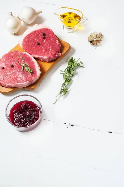 Viande crue à l'huile d'olive, épices et romarin sur planche de bois blanc. Du bœuf frais. Prêt à rôtir — Photo