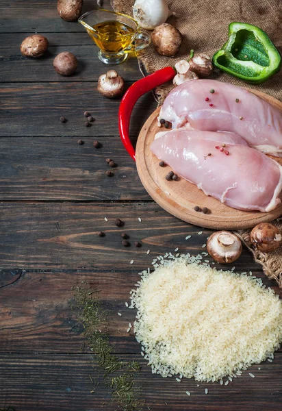 Chiken breast On a cutting board with herbs different fruits and vegetables on rustic wooden background top view — Stock Photo, Image