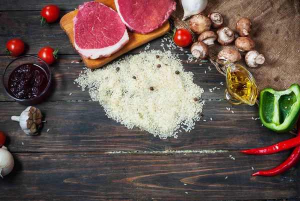 Ingredientes para cocinar una cena de carne saludable. Filetes de ternera crudos sin cocer con champiñones, arroz, hierbas y especias sobre fondo de mesa — Foto de Stock