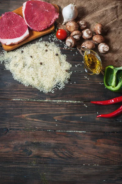 Ingredientes para cocinar una cena de carne saludable. Filetes de ternera crudos sin cocer con champiñones, arroz, hierbas y especias sobre fondo de mesa —  Fotos de Stock