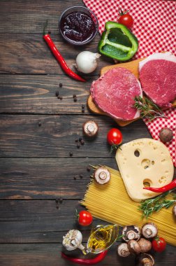 Makarna, domates, mantar ve peynir karanlık tablo arka plan, üstten görünüm gıda kavramı üzerinde ham sığır eti biftek