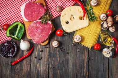 Makarna, domates, mantar ve peynir karanlık tablo arka plan, üstten görünüm gıda kavramı üzerinde ham sığır eti biftek