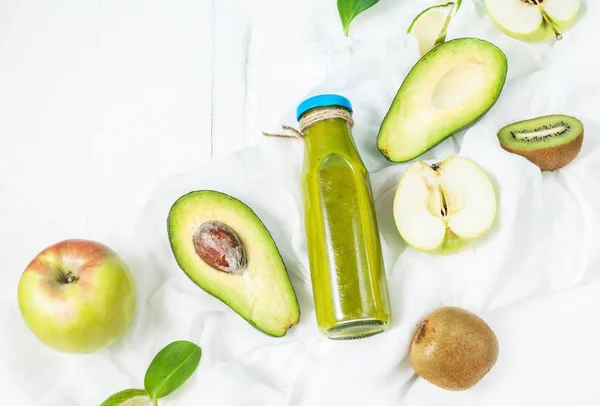 Smoothie vert en bouteille avec avocat, pomme et kiwi sur fond de bois blanc — Photo