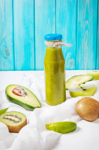 Smoothie vert en bouteille avec avocat, pomme et kiwi sur fond de bois blanc — Photo