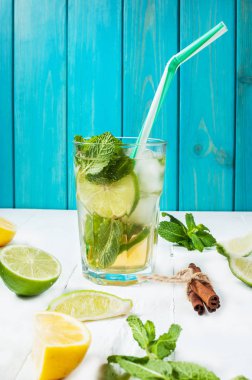 Mojito kokteyl limon ve nane highball cam ahşap bir masa üzerinde. Mavi arka plan