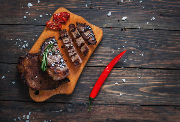 Grilled beef steak seasoned with spices served on a wooden board