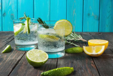 Alkollü içki cin tonik limon, biberiye ve rustik ahşap masa buza kokteyl